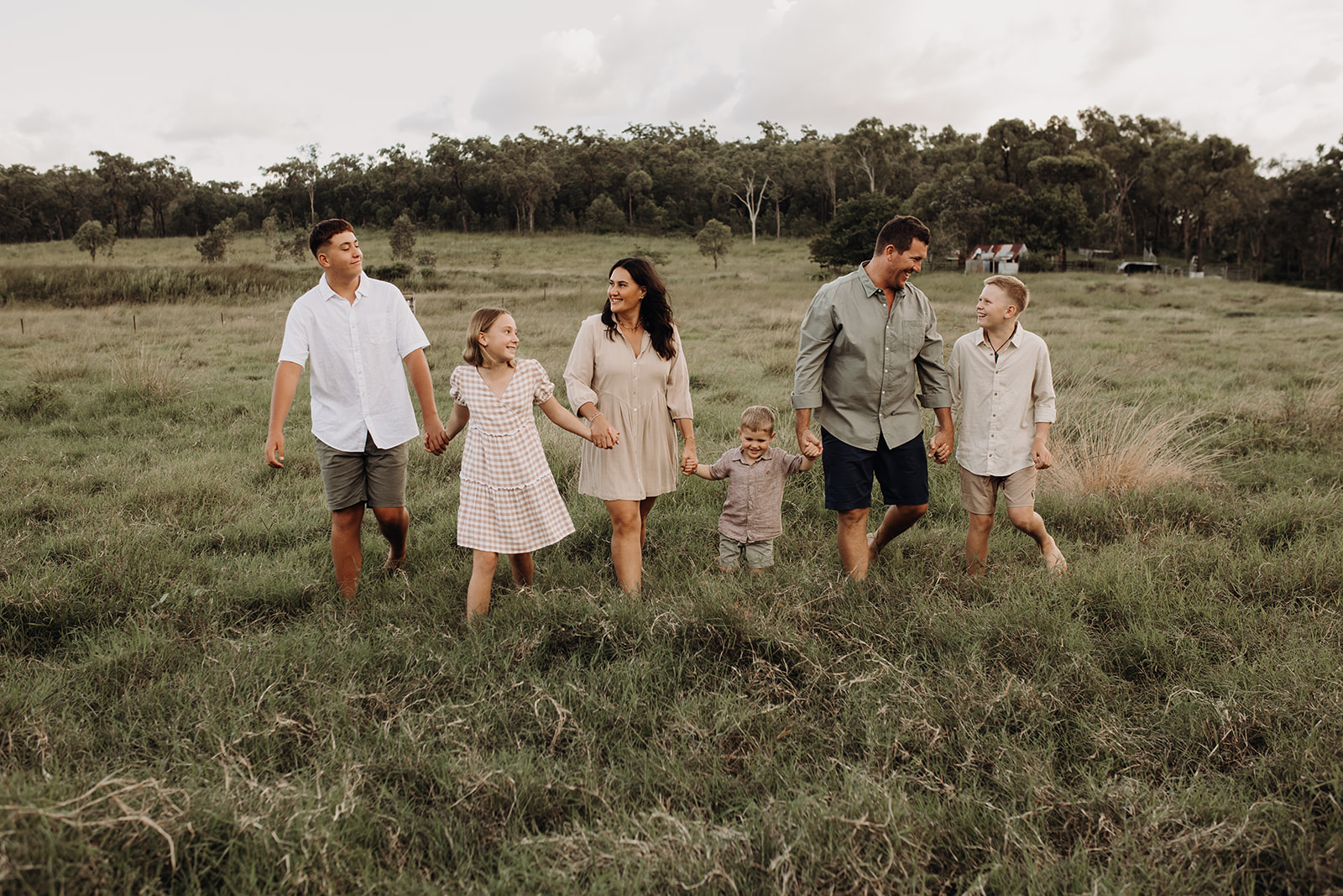 Charlene sitting on a vibrant rug outside near sugarcane fields, playing crystal singing bowls during a sound healing ritual on her cane farm property in Sarina QLD.